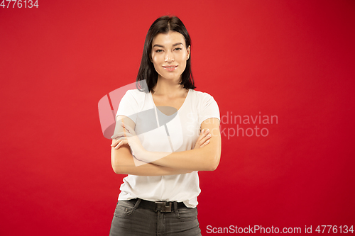 Image of Caucasian young woman\'s half-length portrait on red background
