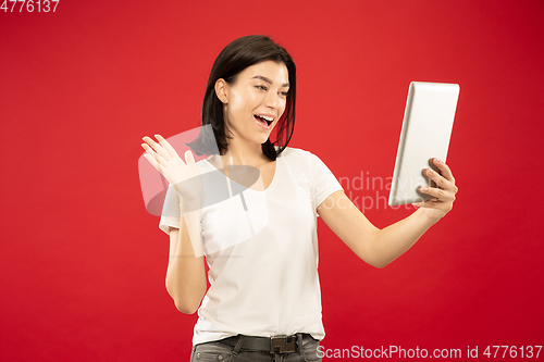 Image of Caucasian young woman\'s half-length portrait on red background