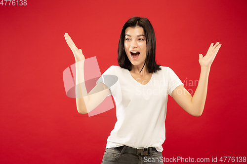 Image of Caucasian young woman\'s half-length portrait on red background