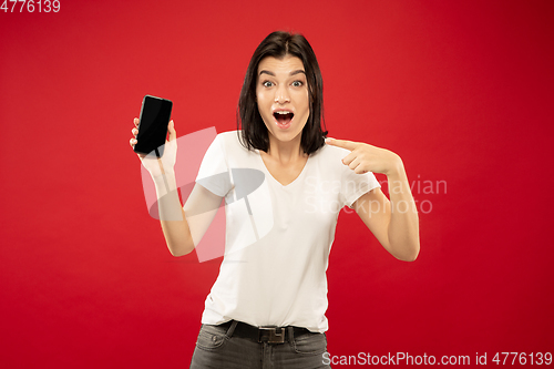 Image of Caucasian young woman\'s half-length portrait on red background