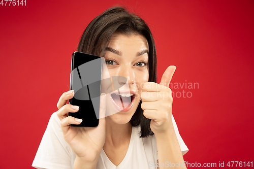 Image of Caucasian young woman\'s half-length portrait on red background