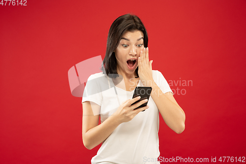 Image of Caucasian young woman\'s half-length portrait on red background