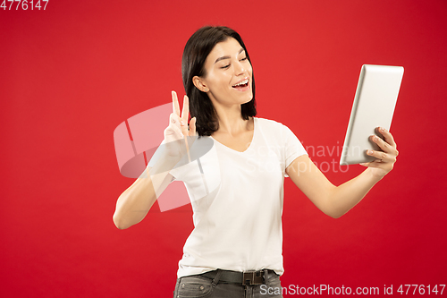 Image of Caucasian young woman\'s half-length portrait on red background