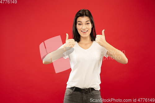 Image of Caucasian young woman\'s half-length portrait on red background