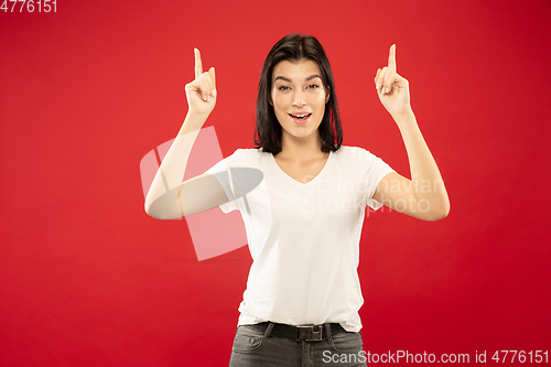 Image of Caucasian young woman\'s half-length portrait on red background