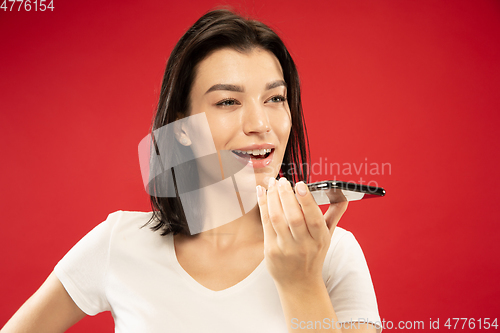 Image of Caucasian young woman\'s half-length portrait on red background