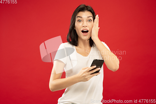 Image of Caucasian young woman\'s half-length portrait on red background