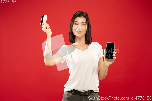 Image of Caucasian young woman\'s half-length portrait on red background