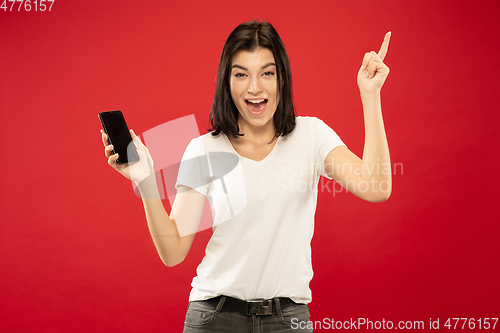 Image of Caucasian young woman\'s half-length portrait on red background