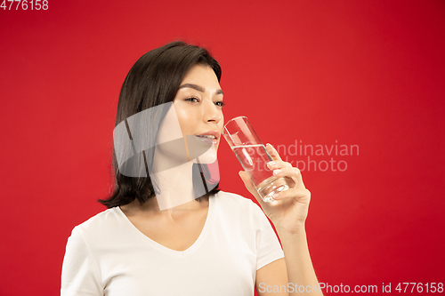 Image of Caucasian young woman\'s half-length portrait on red background