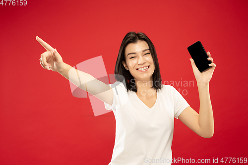 Image of Caucasian young woman\'s half-length portrait on red background