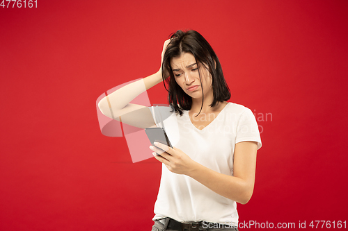 Image of Caucasian young woman\'s half-length portrait on red background