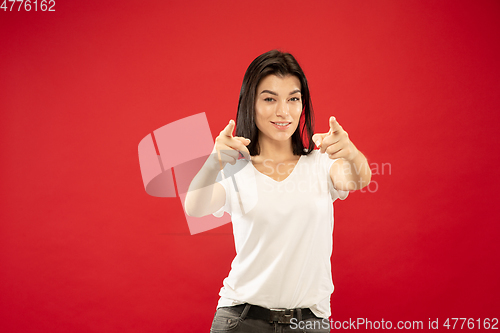 Image of Caucasian young woman\'s half-length portrait on red background