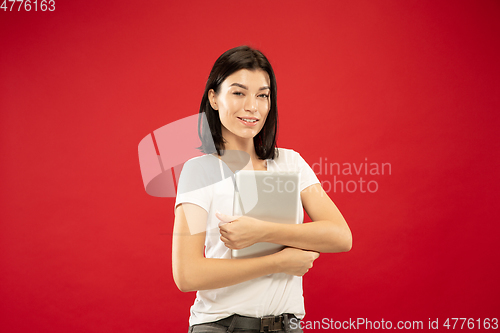 Image of Caucasian young woman\'s half-length portrait on red background