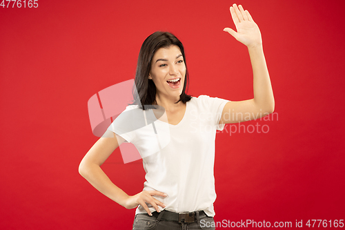 Image of Caucasian young woman\'s half-length portrait on red background