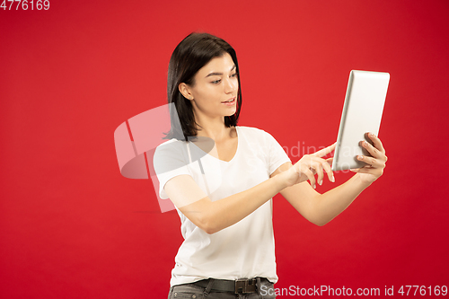 Image of Caucasian young woman\'s half-length portrait on red background