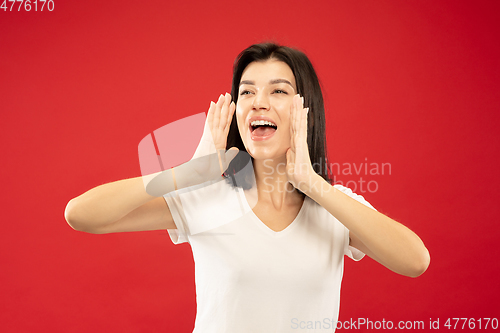 Image of Caucasian young woman\'s half-length portrait on red background