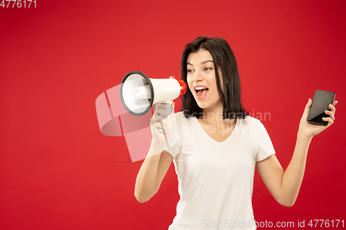 Image of Caucasian young woman\'s half-length portrait on red background