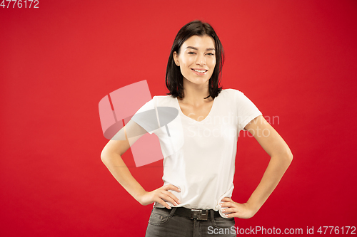 Image of Caucasian young woman\'s half-length portrait on red background