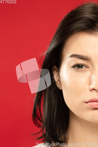 Image of Caucasian young woman\'s close up portrait on red background