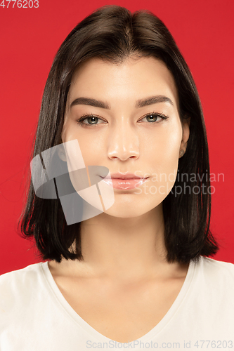 Image of Caucasian young woman\'s close up portrait on red background