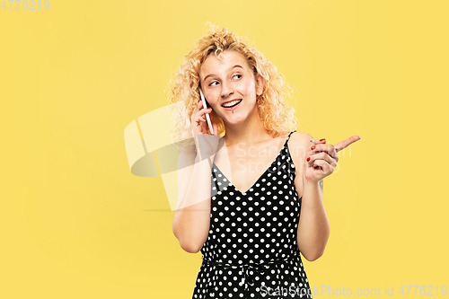 Image of Caucasian young woman\'s half-length portrait on yellow background