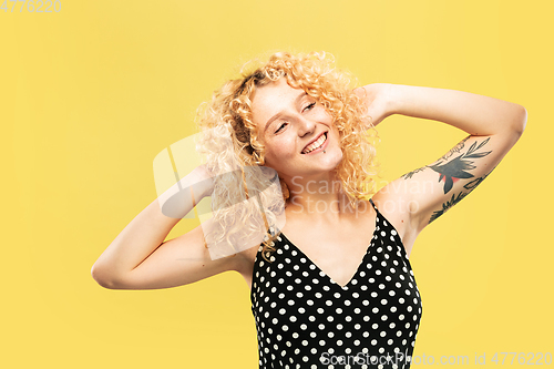 Image of Caucasian young woman\'s half-length portrait on yellow background