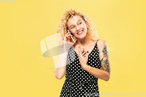 Image of Caucasian young woman\'s half-length portrait on yellow background
