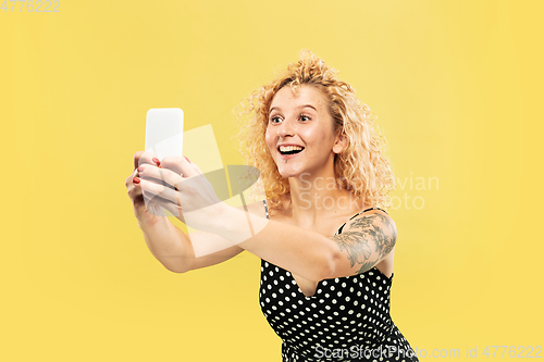 Image of Caucasian young woman\'s half-length portrait on yellow background