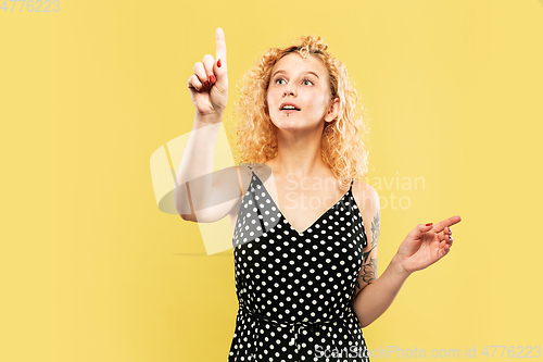 Image of Caucasian young woman\'s half-length portrait on yellow background