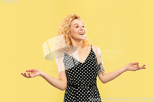 Image of Caucasian young woman\'s half-length portrait on yellow background