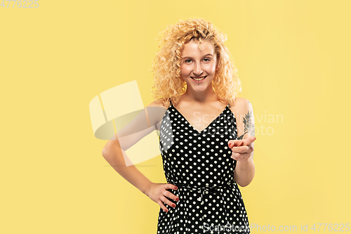 Image of Caucasian young woman\'s half-length portrait on yellow background