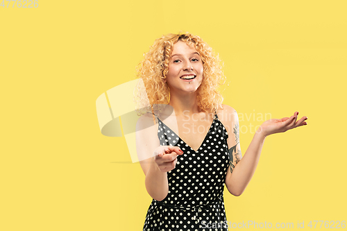 Image of Caucasian young woman\'s half-length portrait on yellow background