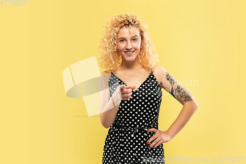 Image of Caucasian young woman\'s half-length portrait on yellow background