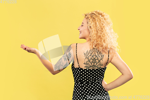 Image of Caucasian young woman\'s half-length portrait on yellow background