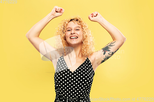 Image of Caucasian young woman\'s half-length portrait on yellow background