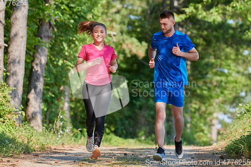 Image of couple enjoying in a healthy lifestyle while jogging on a country road