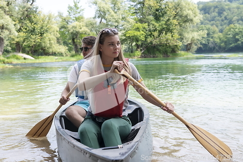 Image of friends are canoeing in a wild river