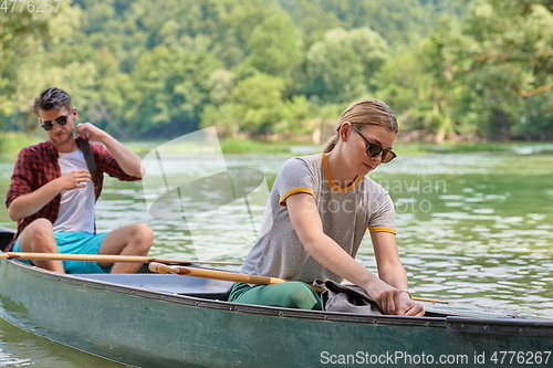 Image of friends are canoeing in a wild river