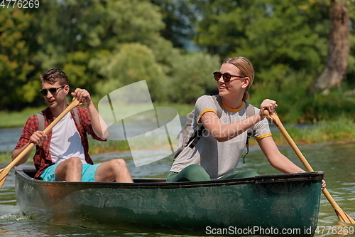 Image of friends are canoeing in a wild river