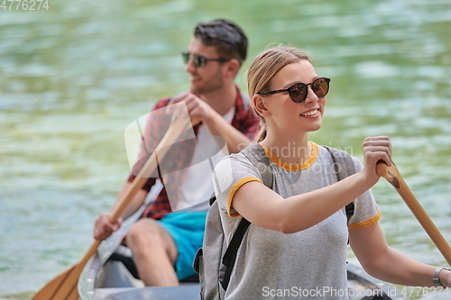 Image of friends are canoeing in a wild river