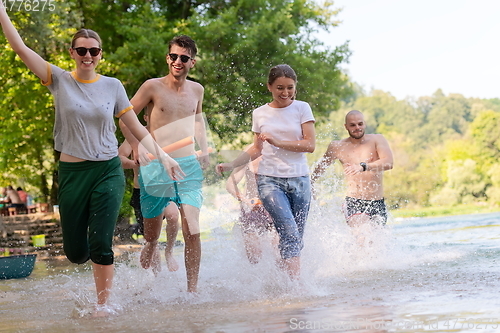 Image of group of happy friends having fun on river