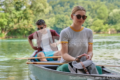 Image of friends are canoeing in a wild river