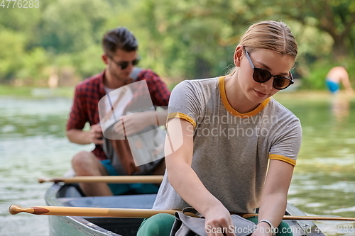 Image of friends are canoeing in a wild river