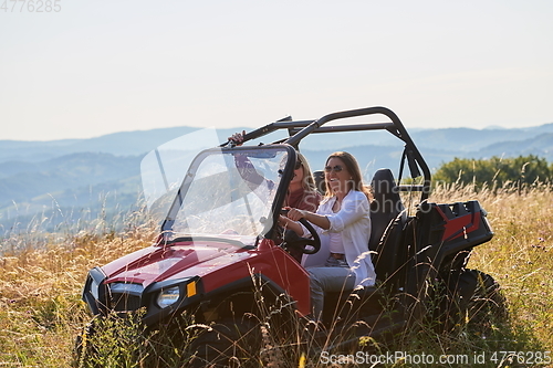 Image of girls enjoying a beautiful sunny day while driving an off-road car