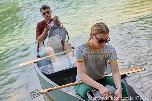 Image of friends are canoeing in a wild river