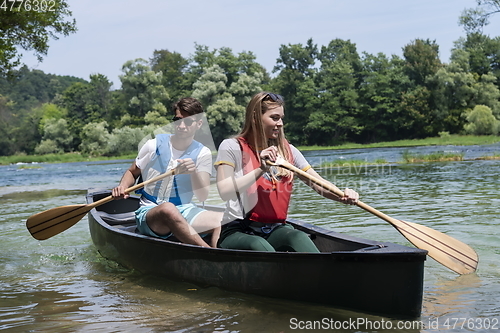 Image of friends are canoeing in a wild river