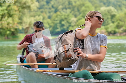 Image of friends are canoeing in a wild river