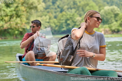 Image of friends are canoeing in a wild river