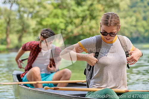 Image of friends are canoeing in a wild river